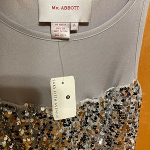 A brand new sequined petite dress has tags on the back has a little pull